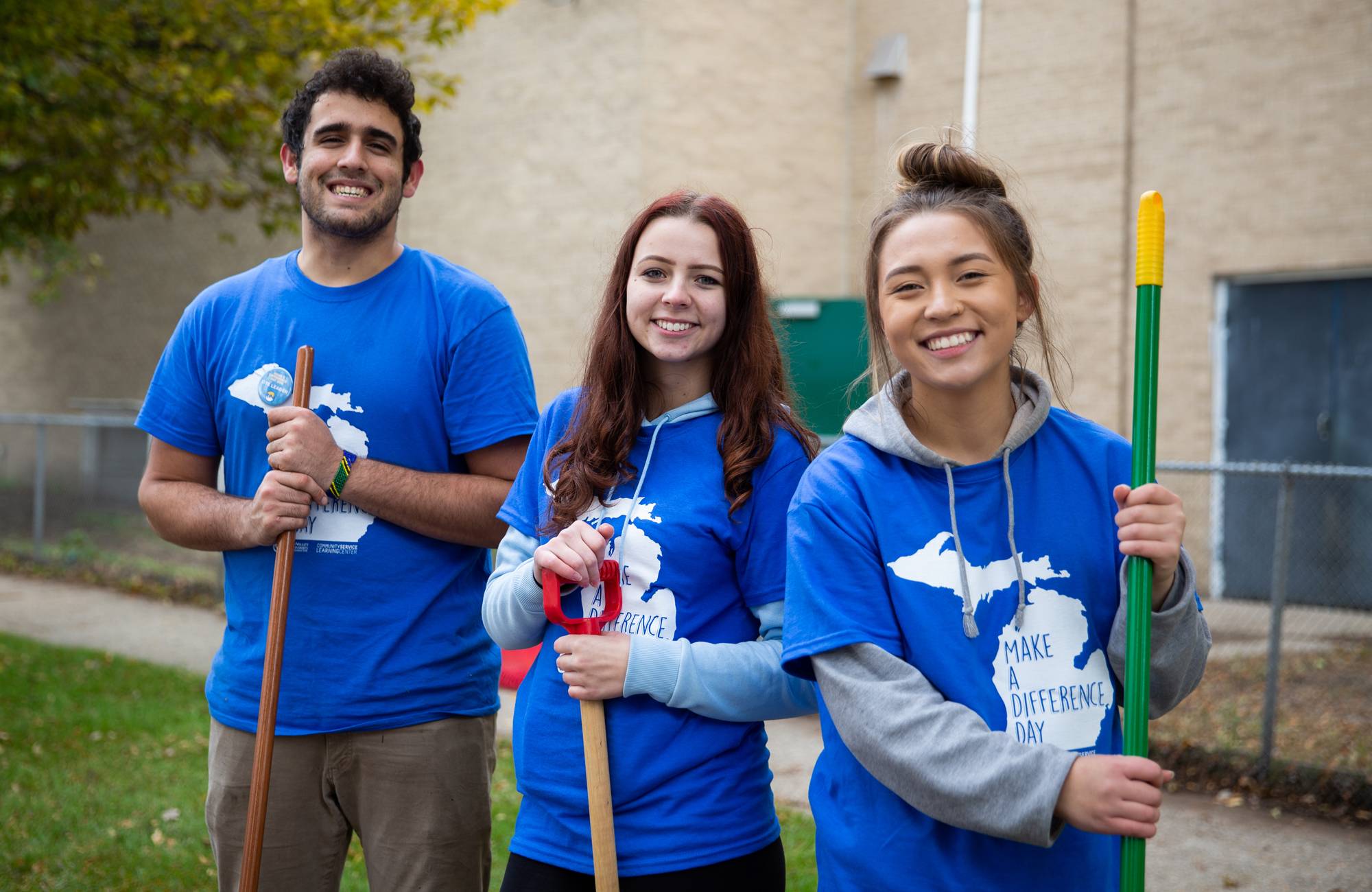 Three student volunteers smiling at camera